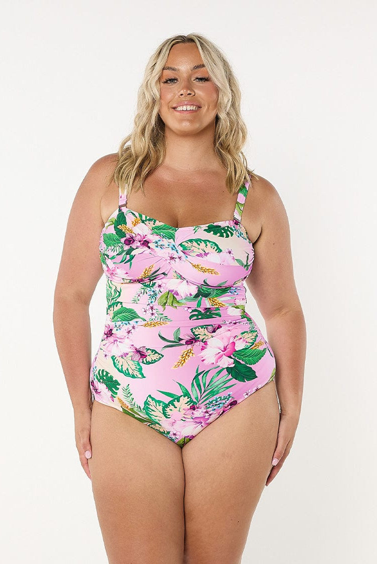 Blonde model in studio wearing a tropial print bandeau one piece with removable and adjustable straps