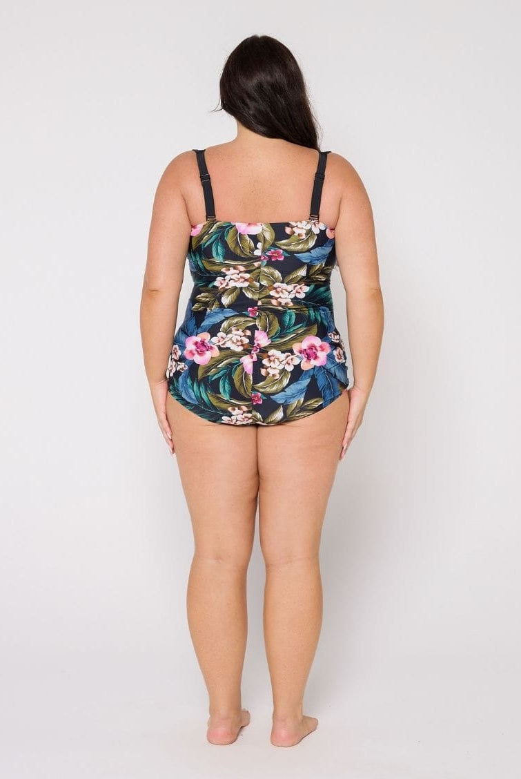 Woman wearing a floral swimsuit with adjustable straps against a white background