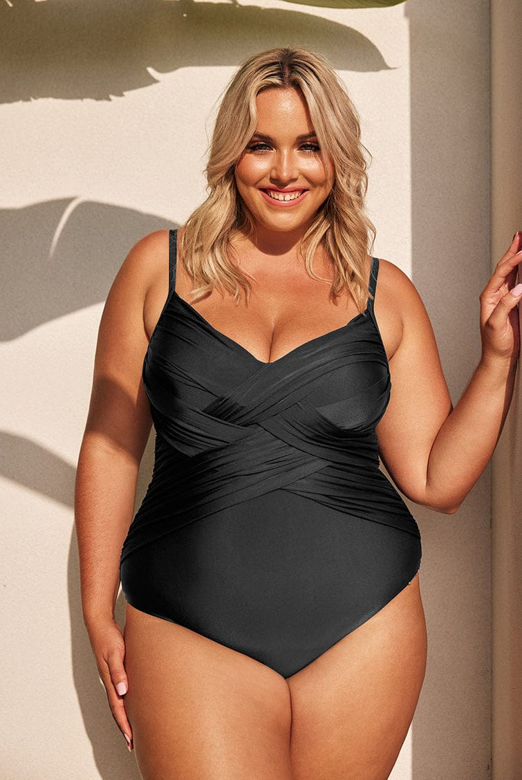 Woman wearing a black swimsuit against a neutral background
