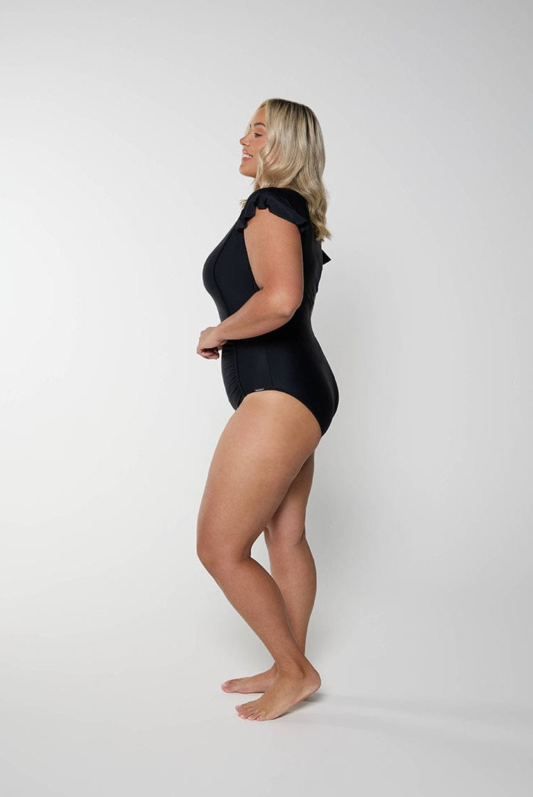 Woman wearing a black swimsuit against a white background