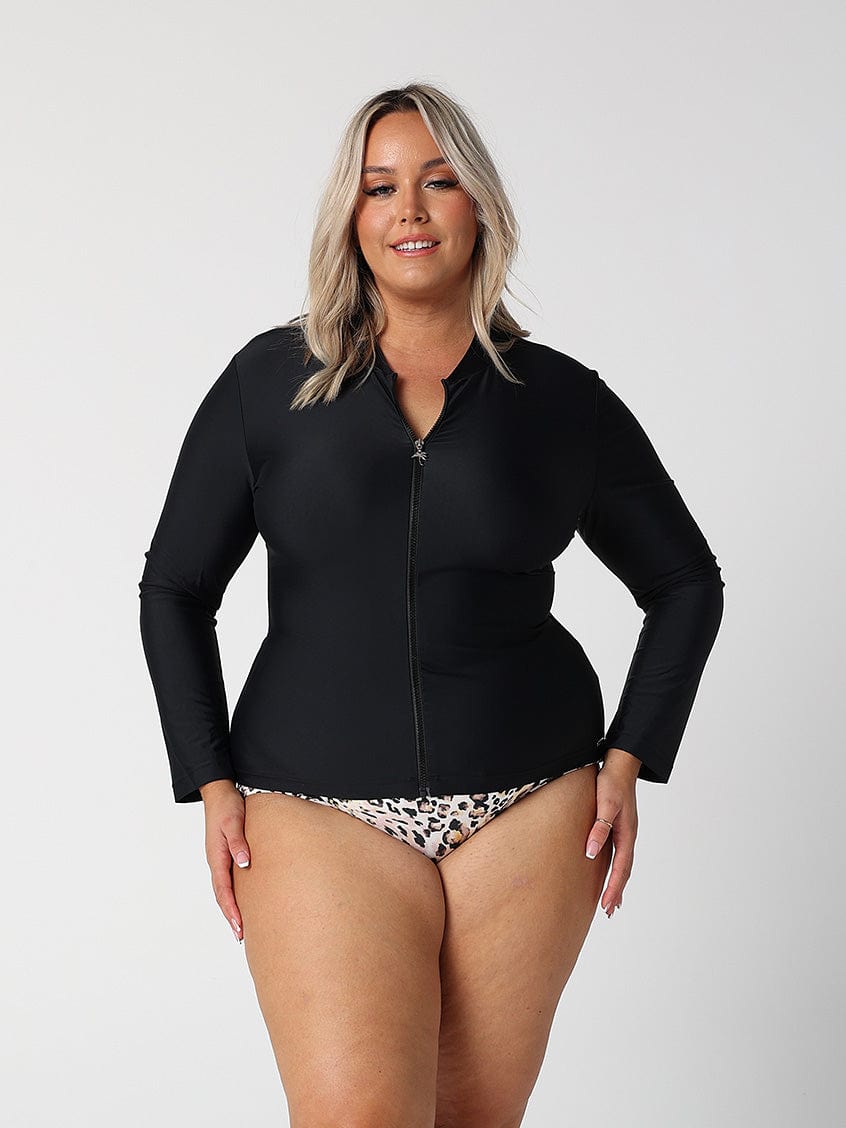 Brunette plus size model wearing long sleeve rash vest in black