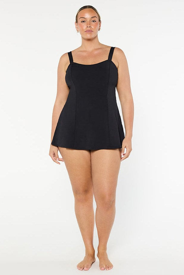 Person wearing a black tank top against a white background