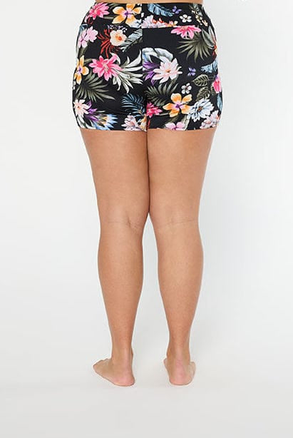 Woman wearing a black floral high-waisted bikini bottom on a white background