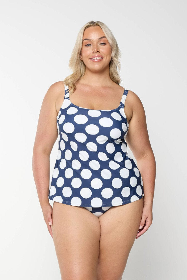Blonde model shows tummy control swim bottom in navy and white polkadot pattern