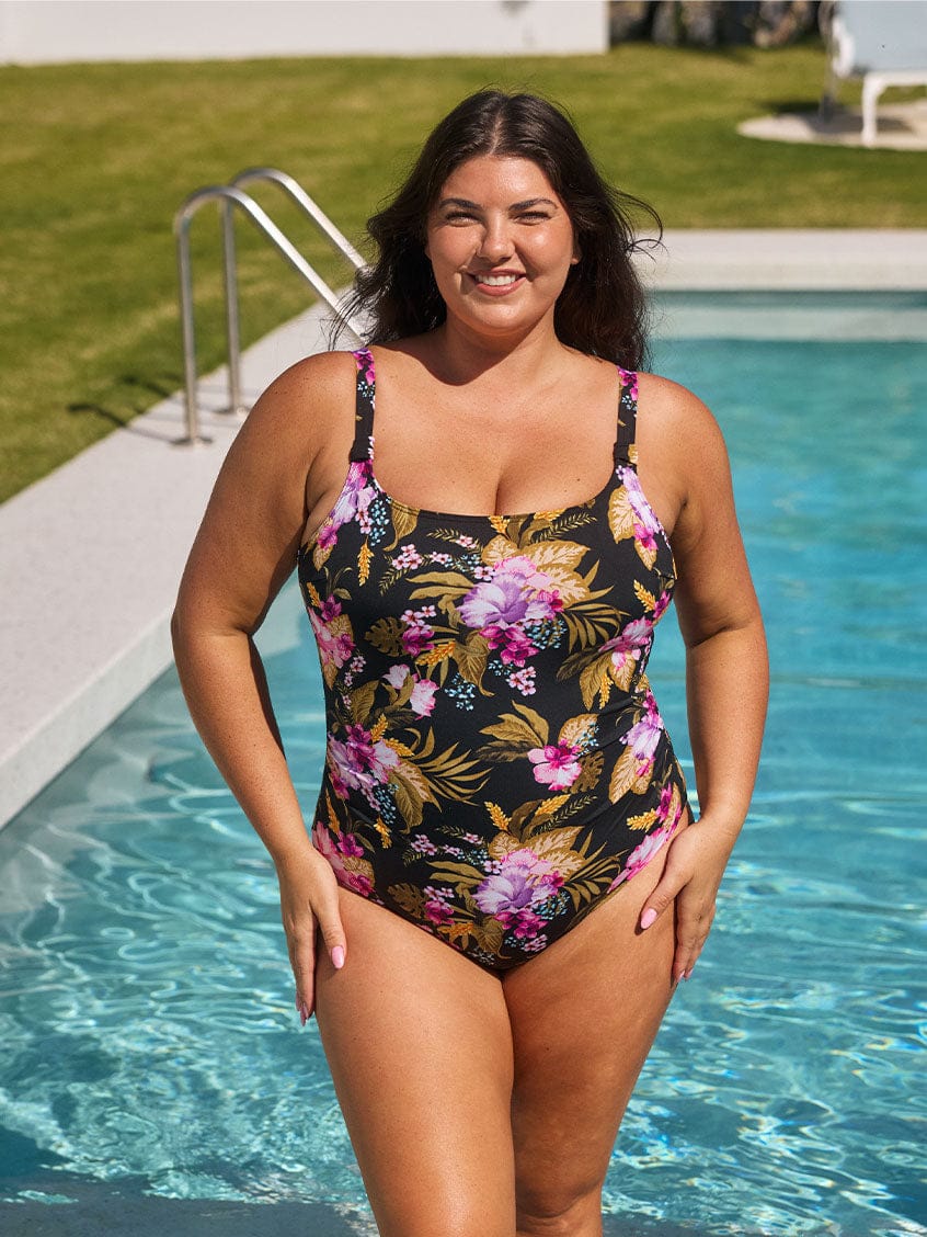 Brunette model wears flattering chlorine resistant scoop neck one piece swimsuit