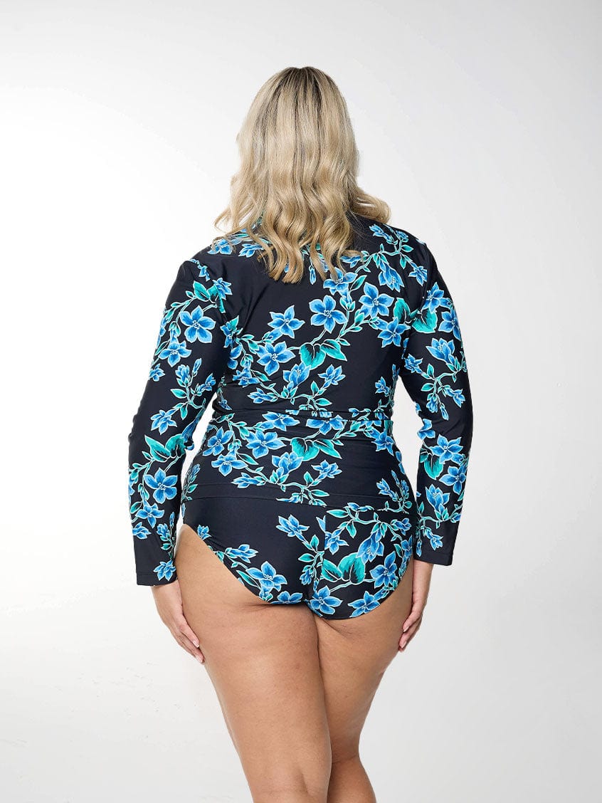 Blonde model shows back of long sleeve rash vest in blue floral print