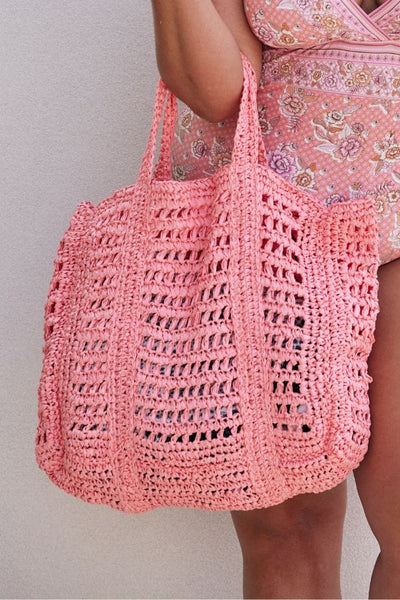 Model wearing peach coloured handmade crochet tote bag on arm