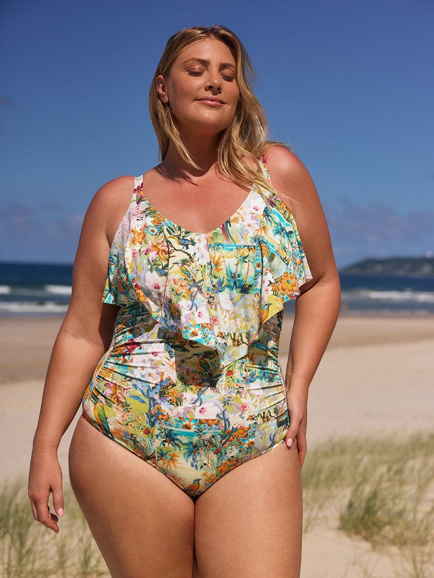 Woman wearing a colorful floral swimsuit on a beach