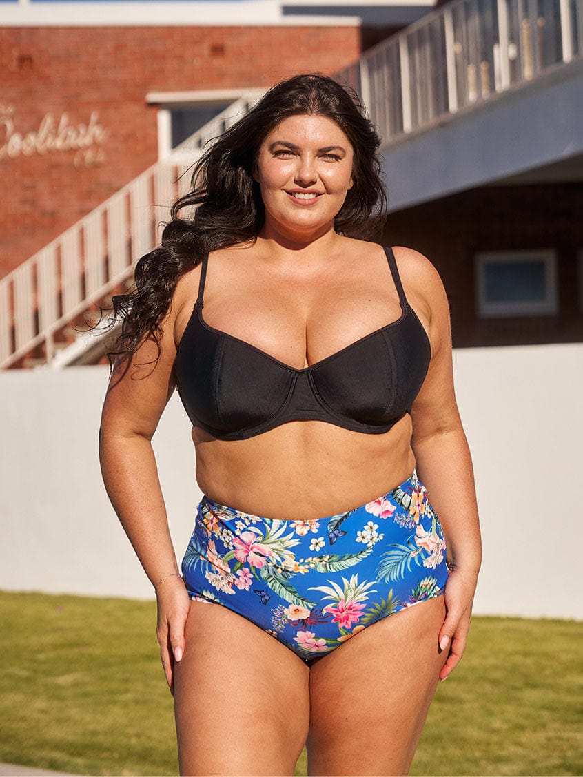 Brunette model wears flattering high rise blue floral swim bottom