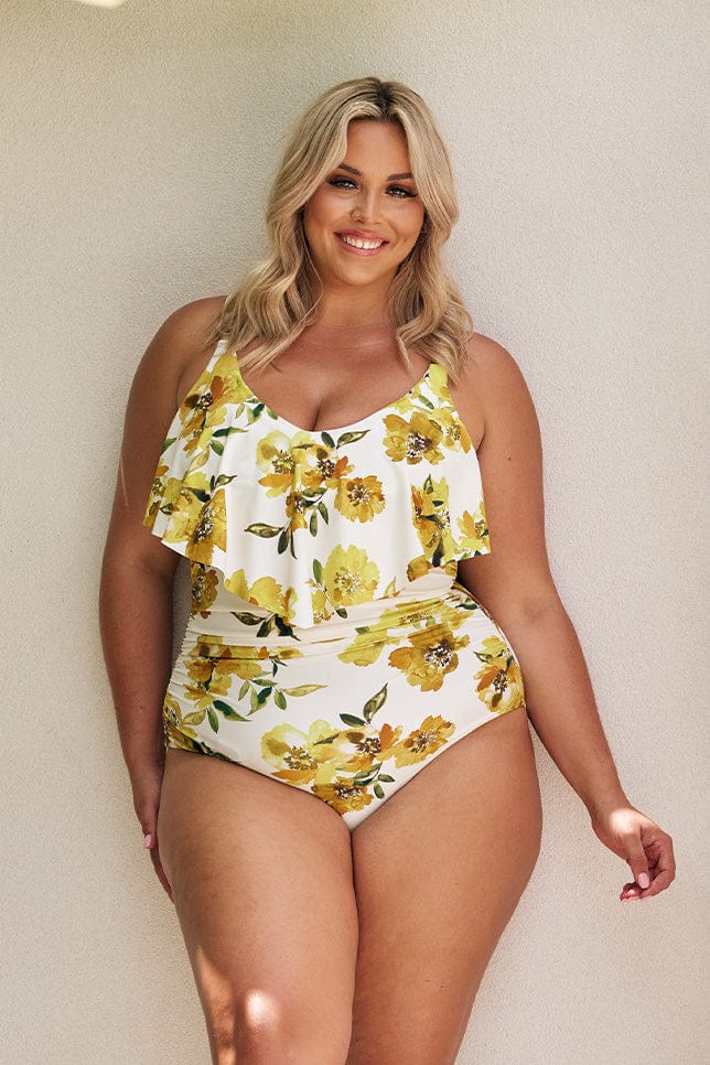 Blonde model wearing white and yellow floral v neck swimsuit