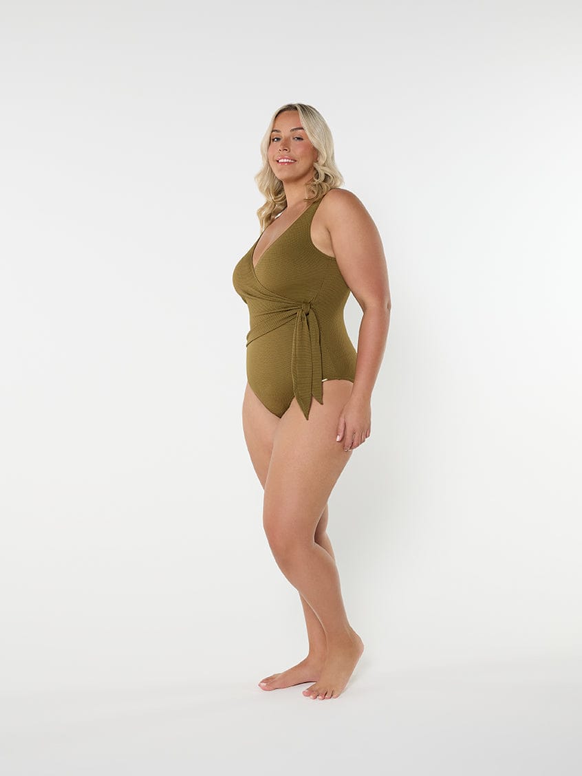 Woman wearing a green swimsuit on a white background