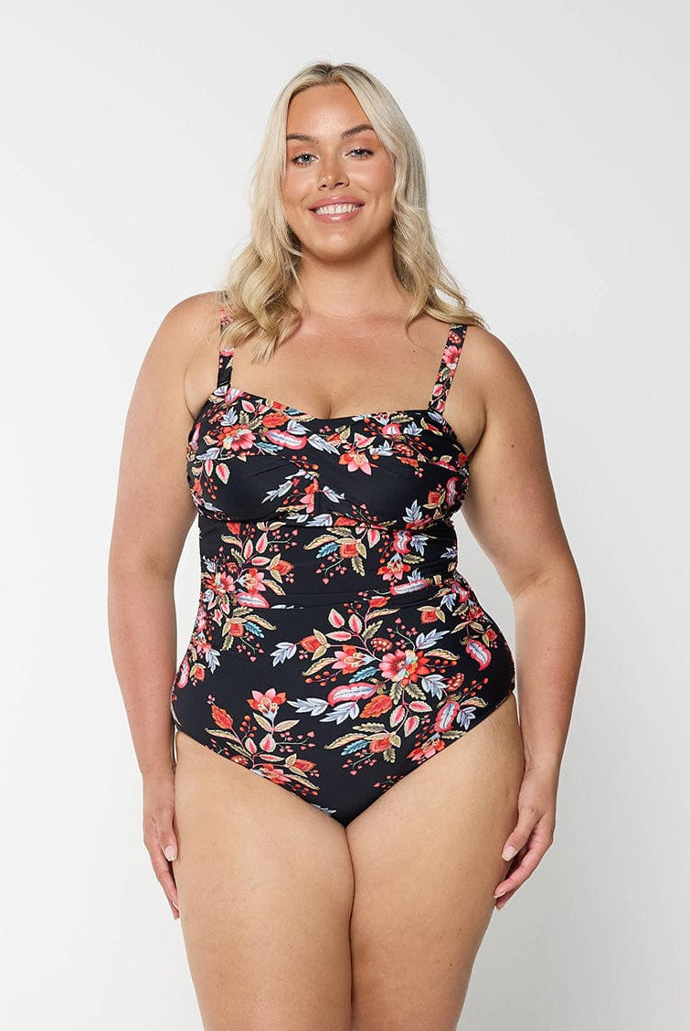 model wearing black and red floral curvy women's one piece