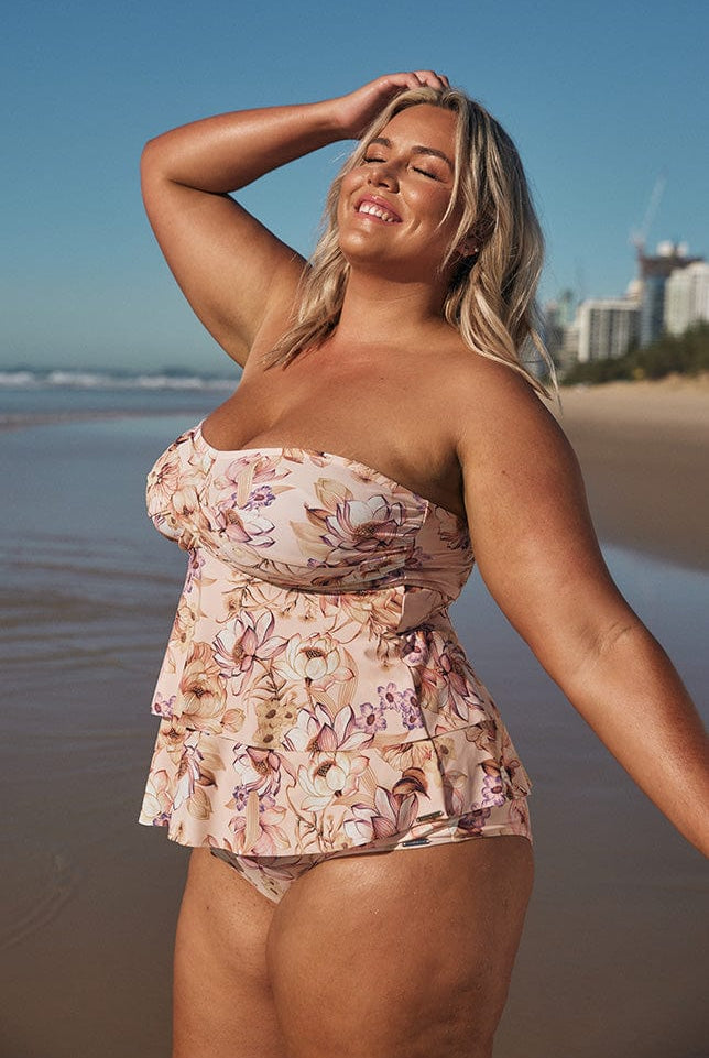 Blonde model wearing light pink strapless swim tankini top