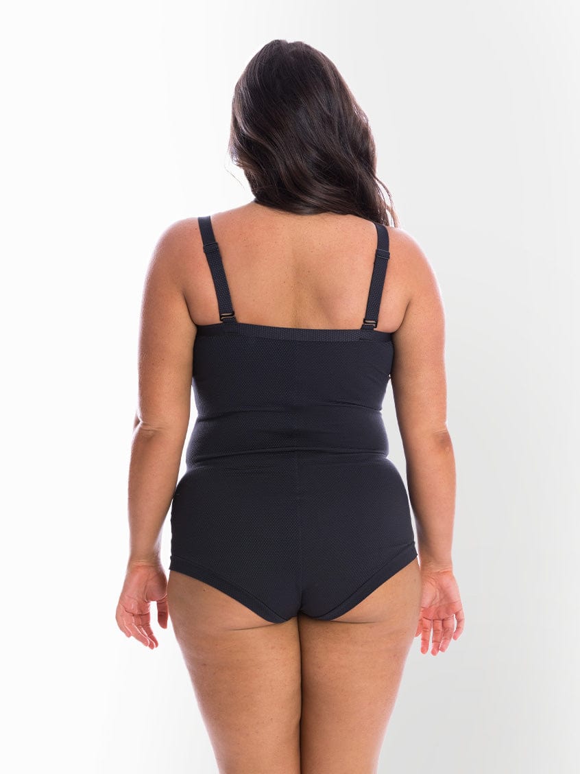 model showing back of black textured boyleg swimsuit