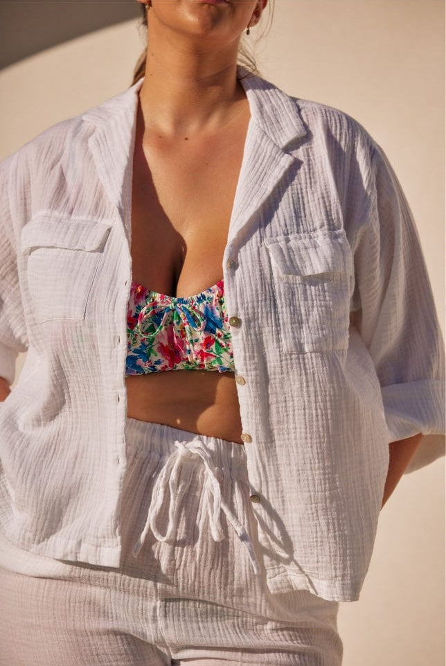 close up photo of a white cheesecloth button through shirt