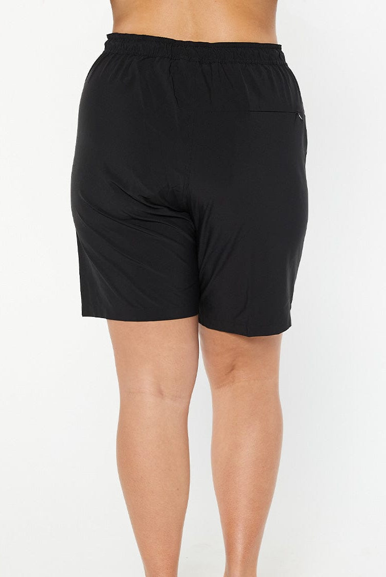 model wearing plain black board shorts
