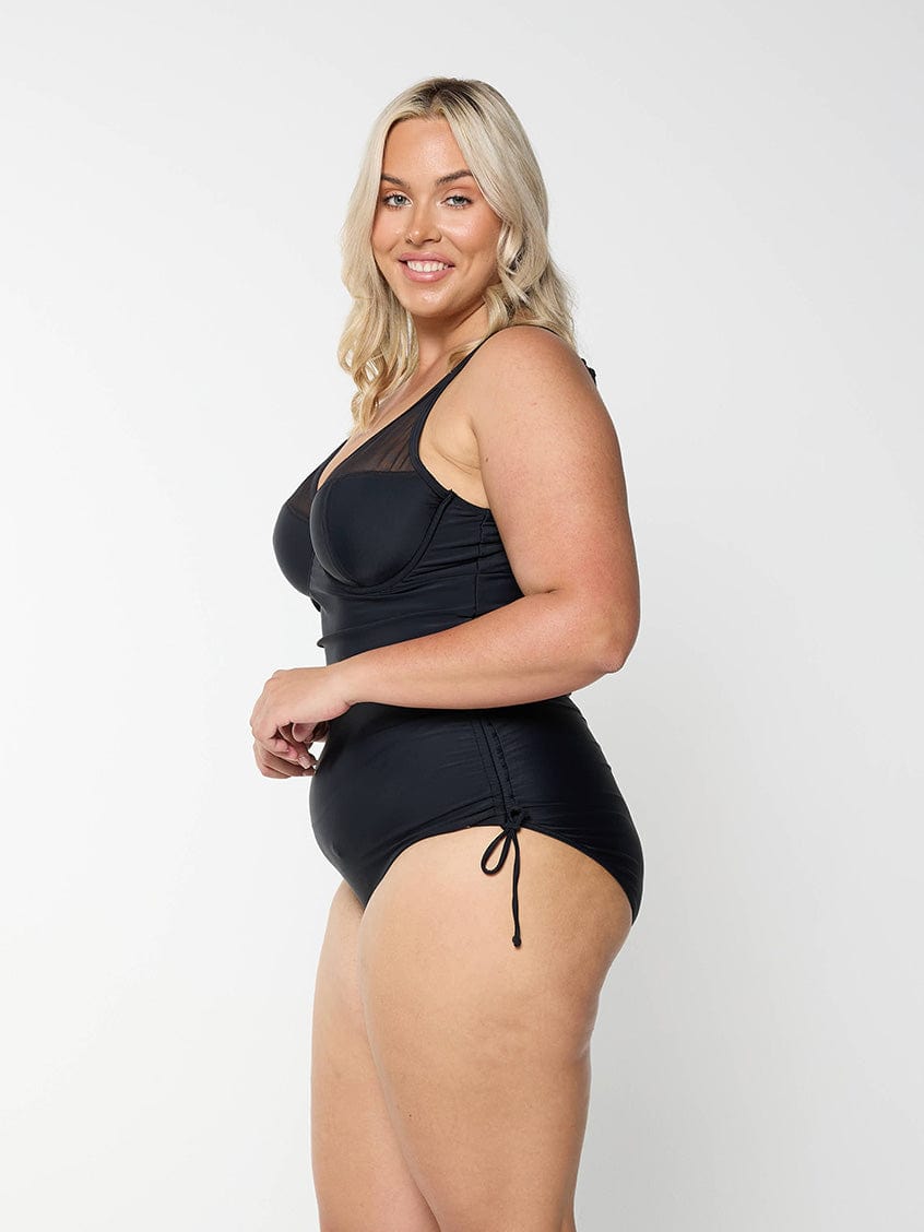model wearing black mesh detail swimsuit with adjustable side ruching