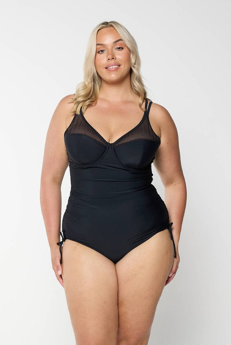 model wearing black mesh one piece with tie sides
