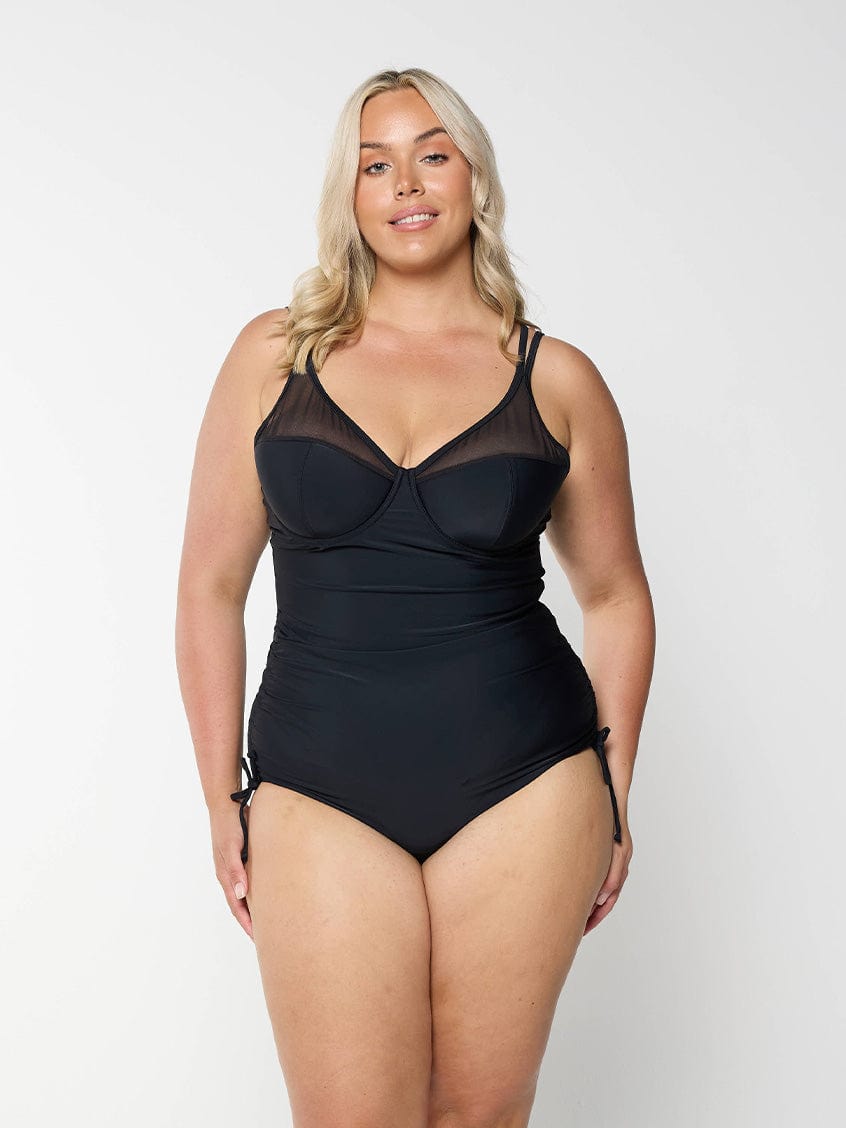 model wearing black mesh one piece with tie sides