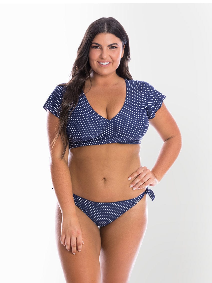 model wearing navy polka dot bikini top and tie bottoms