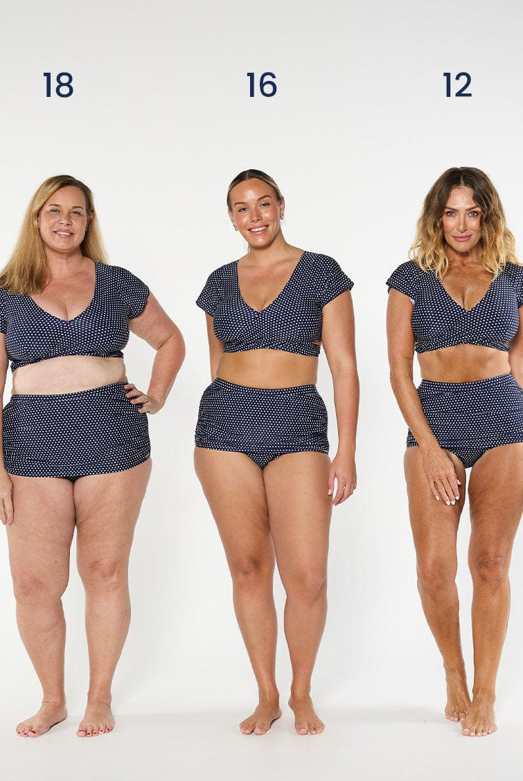 three models wearing navy polka dot wrap top with matching skirted pant