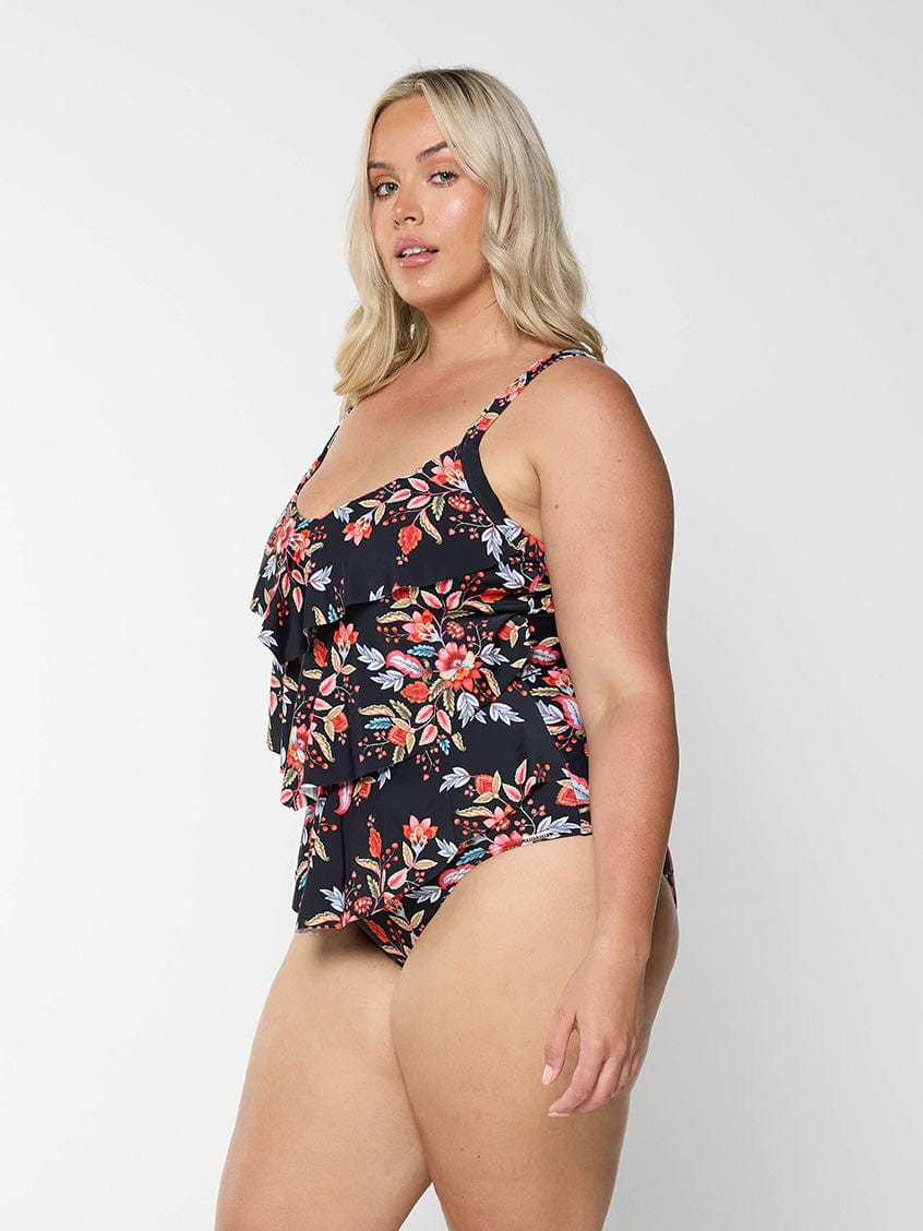 model showing side of black and red floral three tier swimsuit