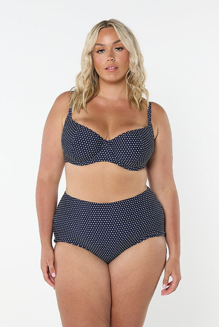 Woman wearing a navy polka dot bikini set