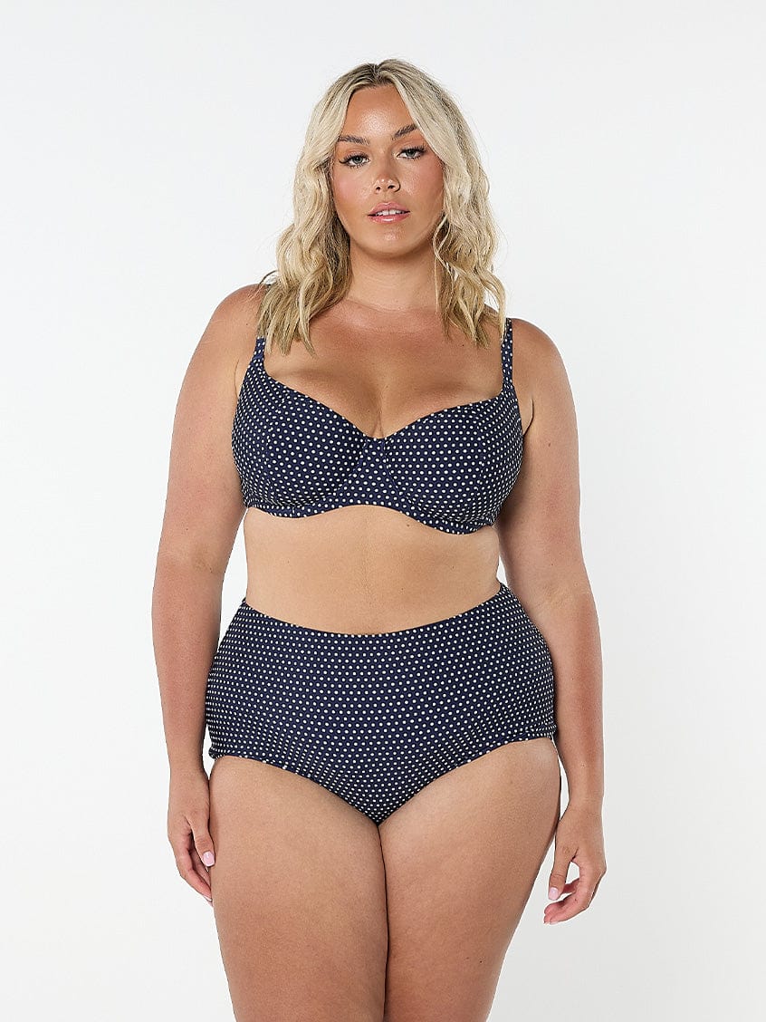Woman wearing a navy polka dot bikini set