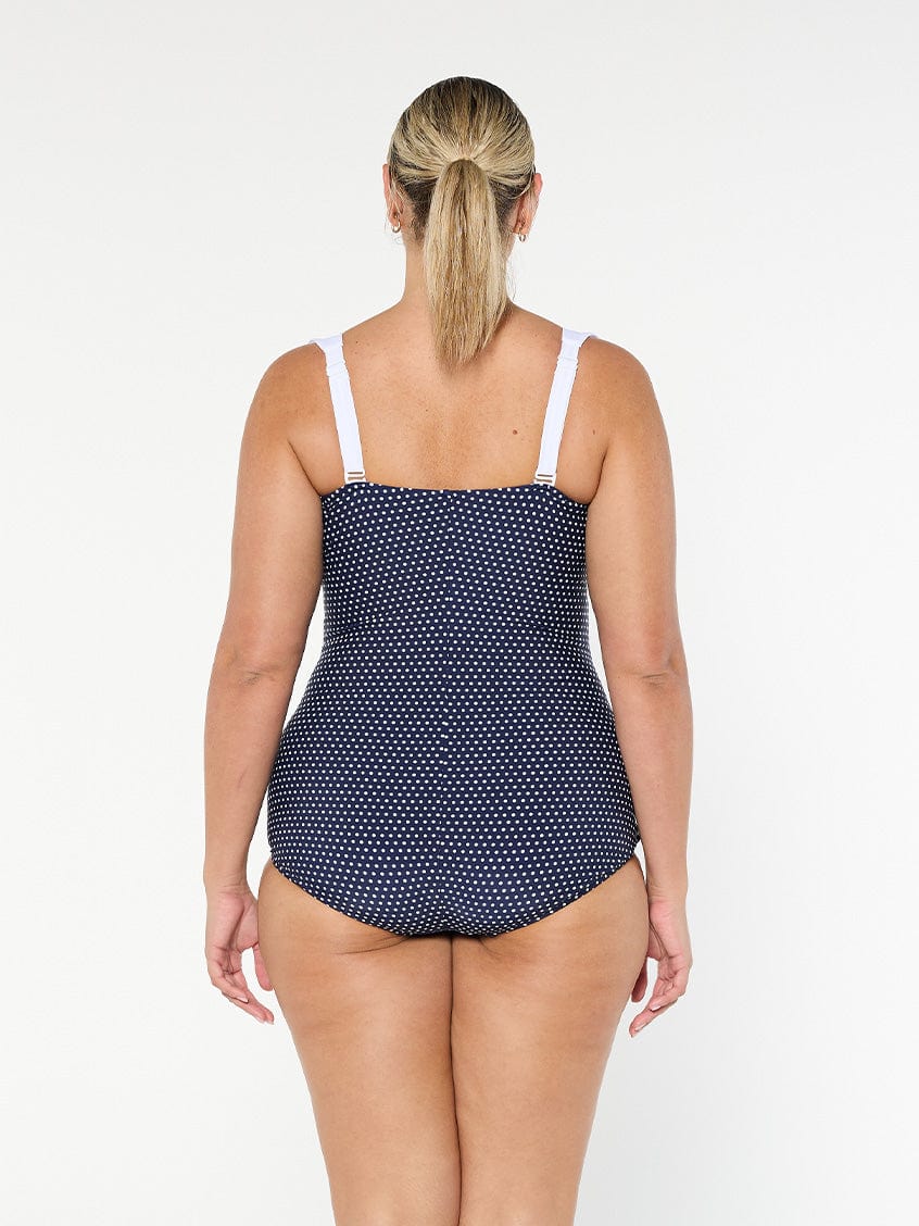 model showing back of navy and white dots swimsuit