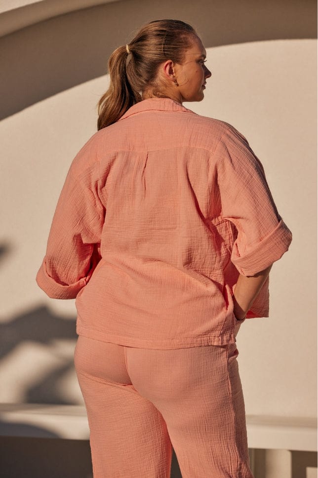 back of model wearing a musk pink crepe fabric lounge wear set with rolled up sleeves