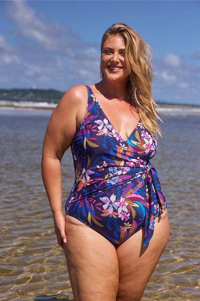 Blonde women on beach wearing navy based floral one piece