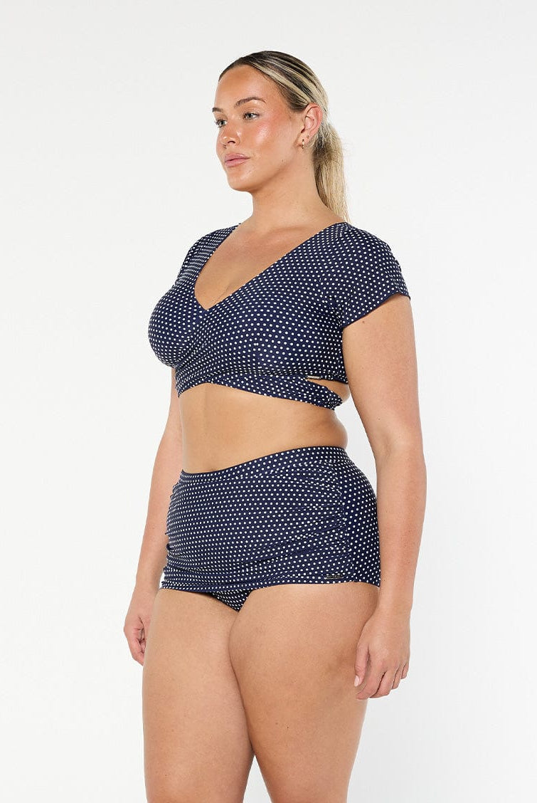 model showing side of navy and white dots skirted bikini pant