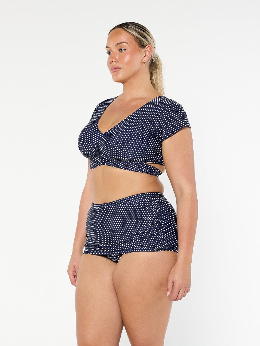 model showing side of navy and white dots skirted bikini pant