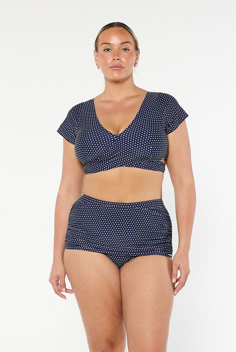 model wearing navy and white dots wrap swim top