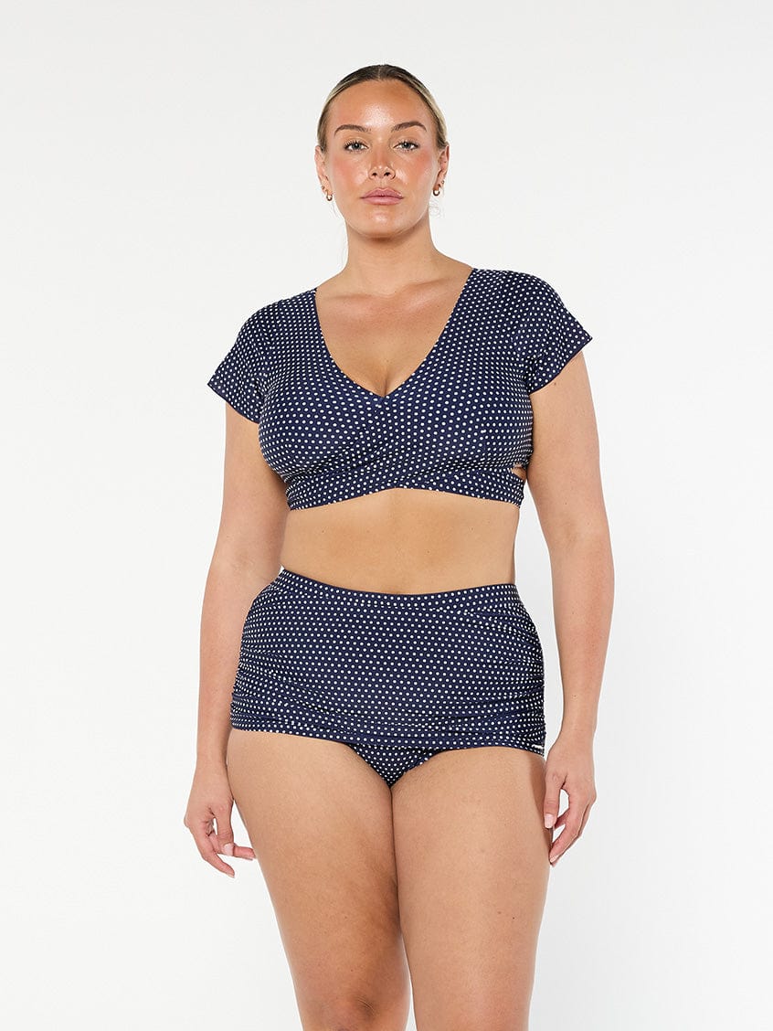 model wearing navy and white dots wrap swim top