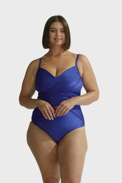 Model wears metallic blue criss cross swimwear