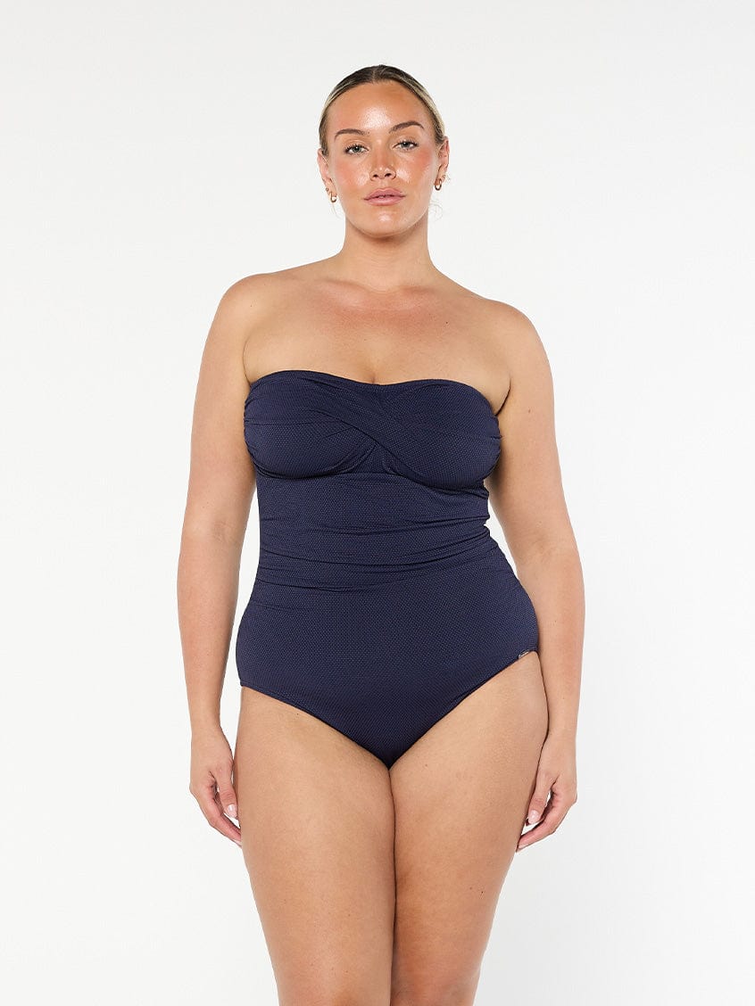 model wearing navy honey comb strapless one piece