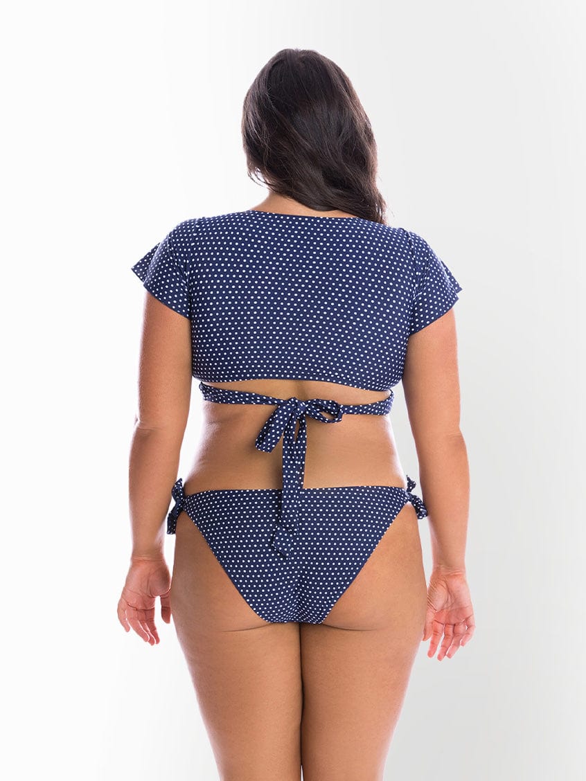 model showing back of navy and white dots tie bikini bottom