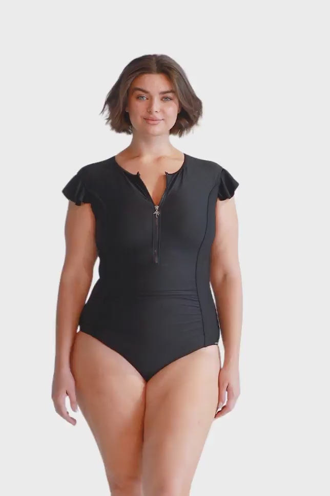 brunette plus size model wears black high neck zip front one piece with cap sleeves