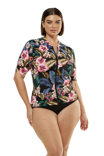 Model wearing a short sleeve rash vest with zip in a black floral print