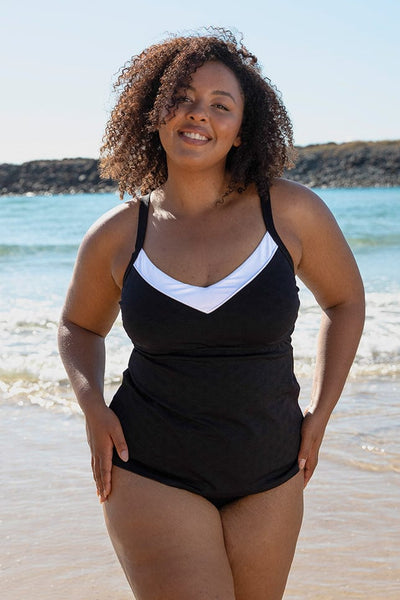 size 16 women standing on a beach wearing supportive underwire tankini top in textured black and white fabric