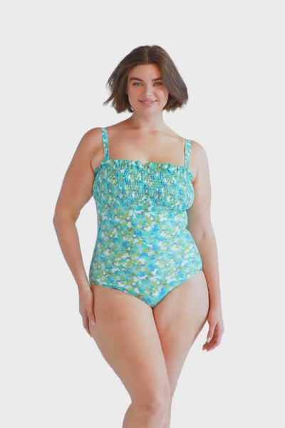 brunette plus size model wears turquoise blue shirred bandeau one piece with removable straps