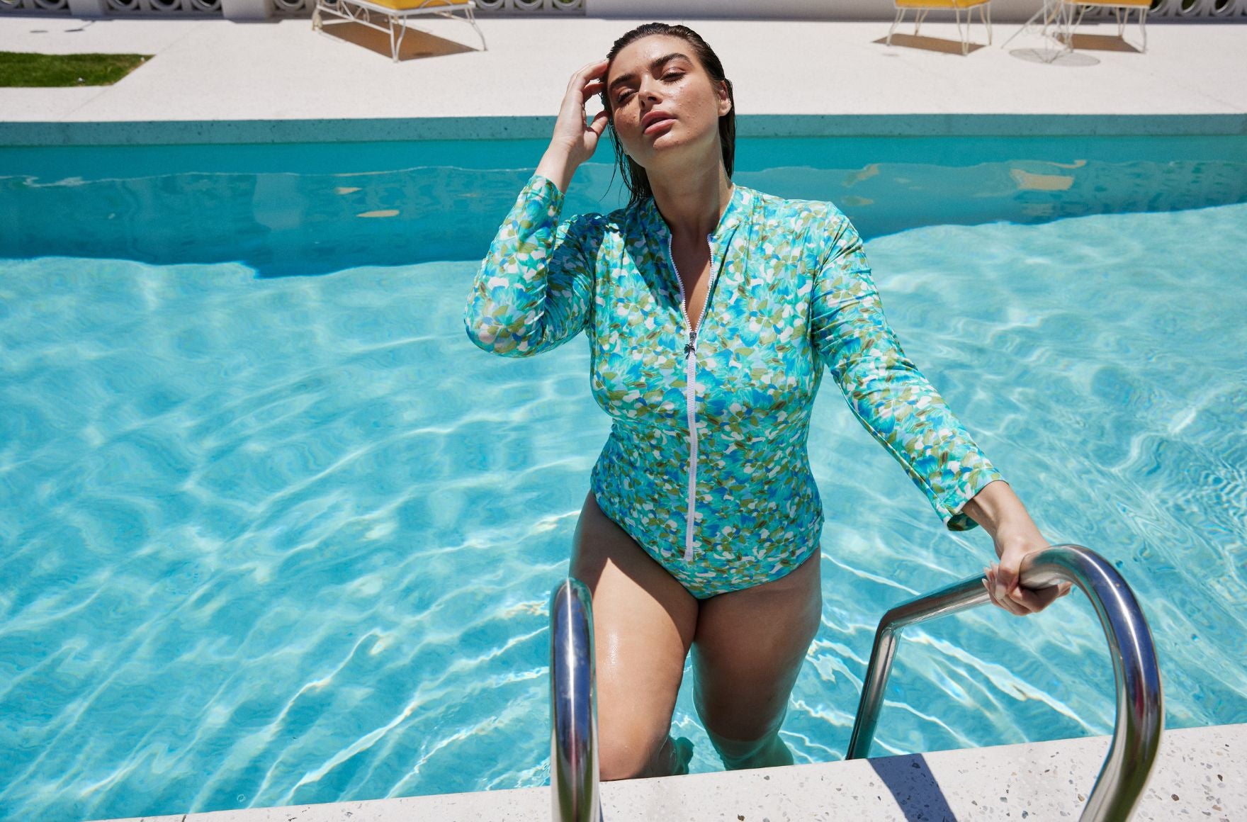 Woman with short brown hair wears Calypso long sleeve rash vest