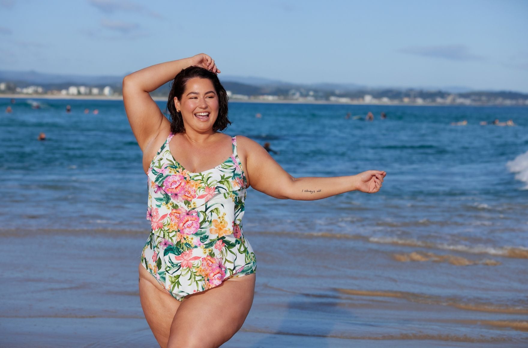 Woman with short brown hair wears Bora Bora white floral 3 tier ruffle one piece swimsuit
