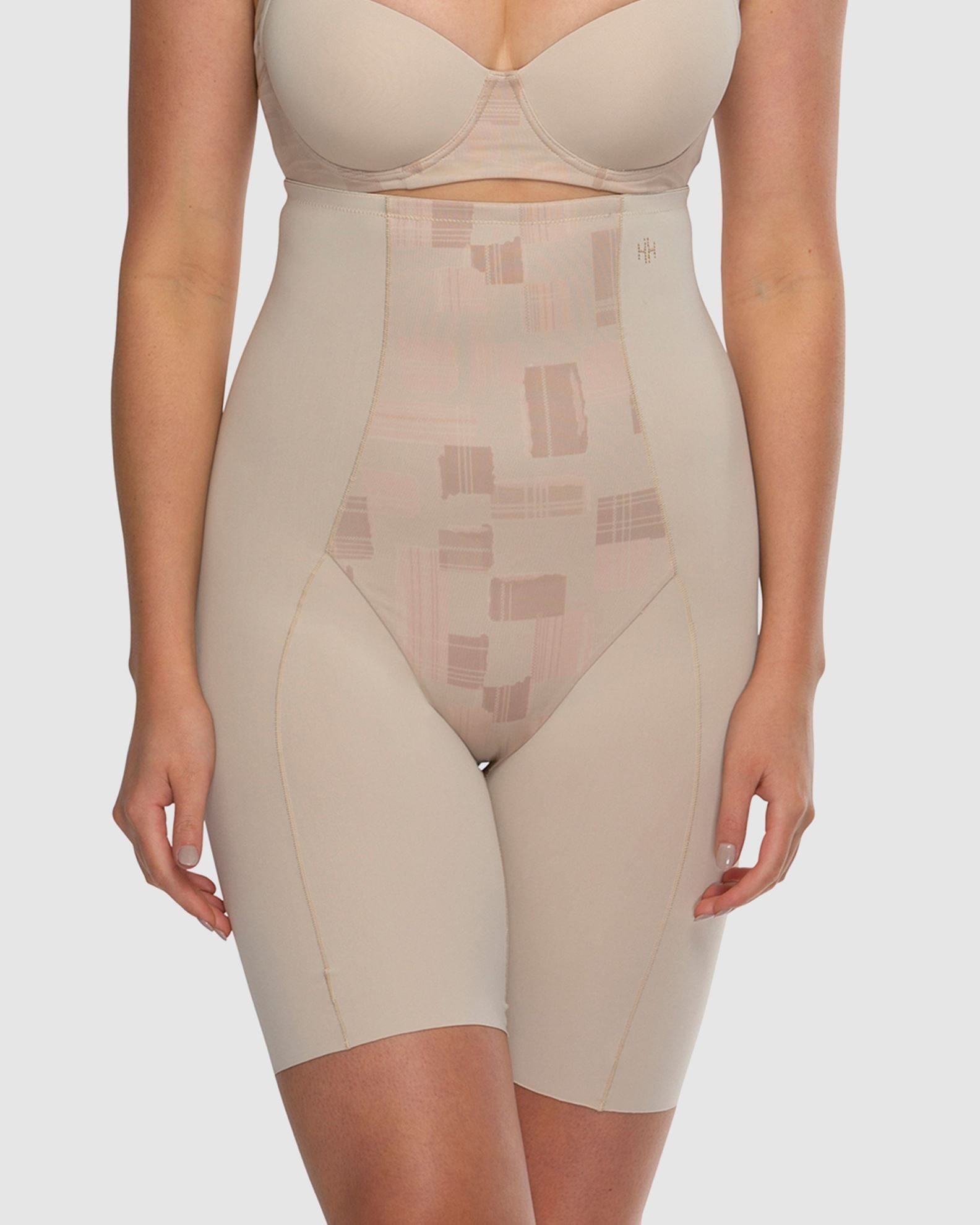 Beige shapewear garment worn by a model on a plain background