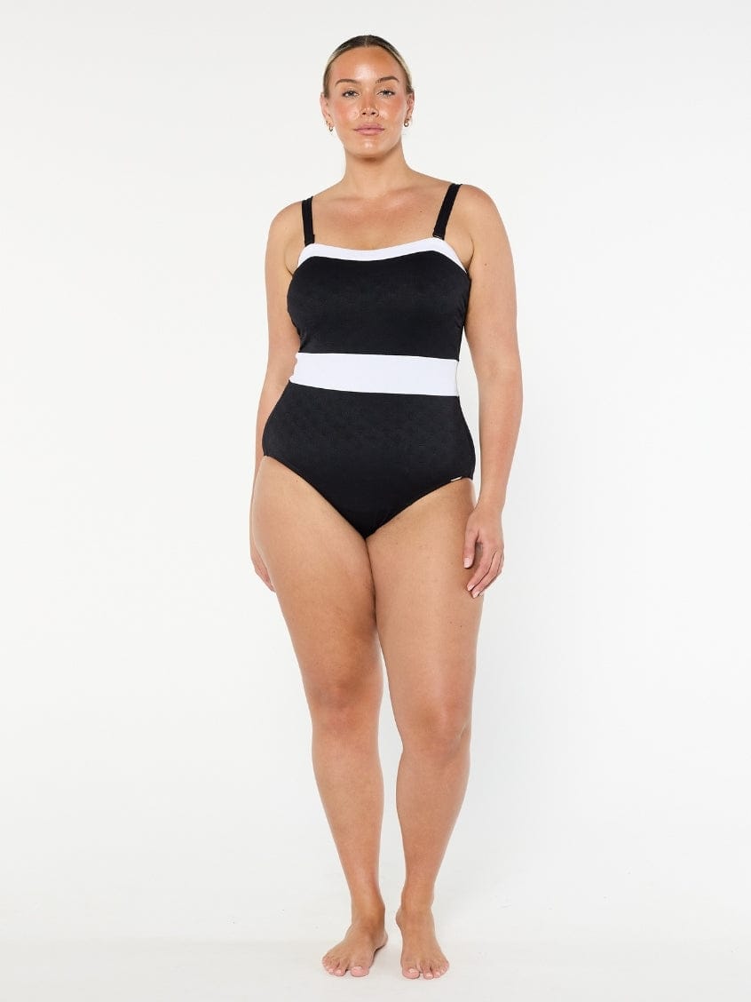 Woman wearing a black and white swimsuit on a white background