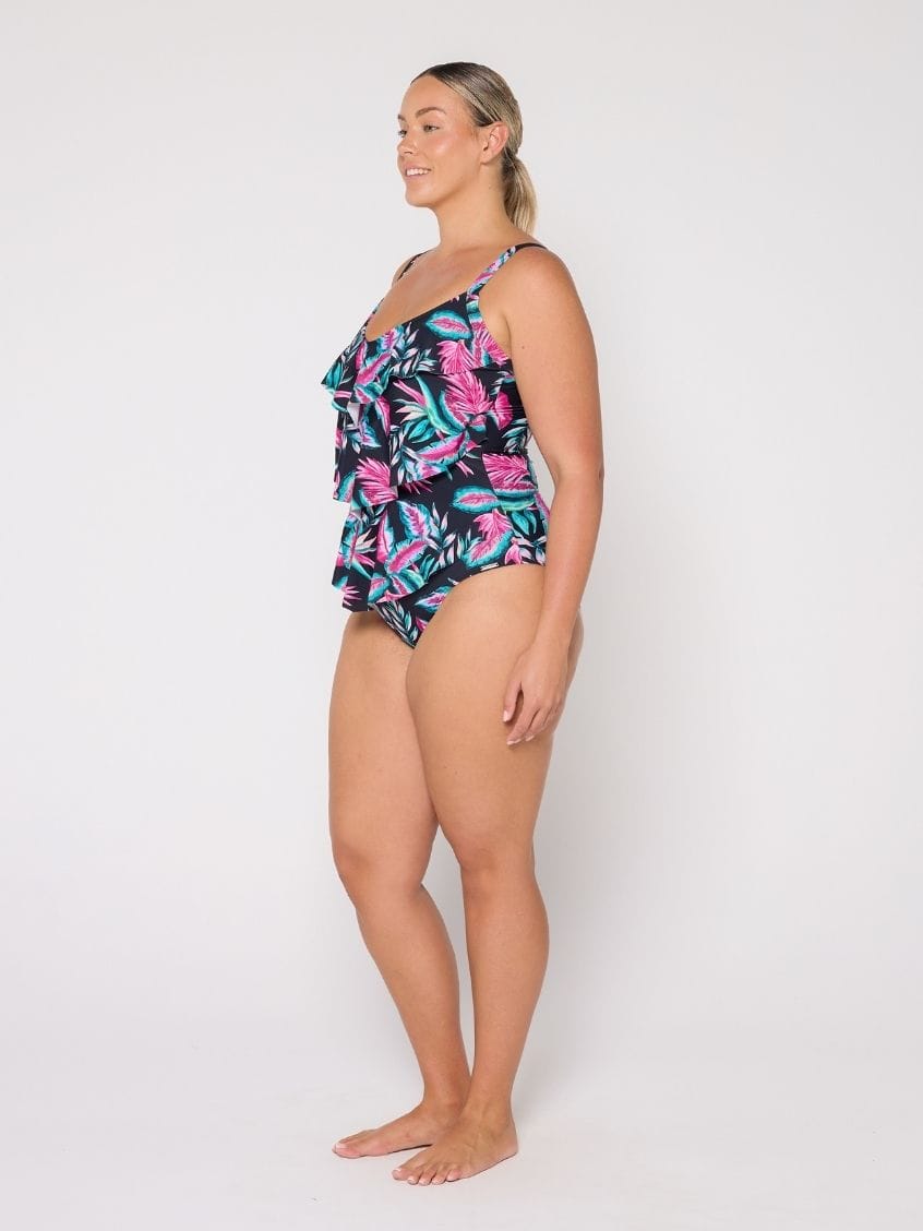 Woman wearing a tiered designfloral swimsuit on a white background