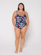 Woman wearing a tropical leaf patterned swimsuit on a white background