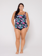 Woman wearing a colorful floral swimsuit against a white background