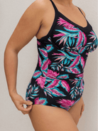 Black swimsuit with pink and blue leaf pattern on a neutral background